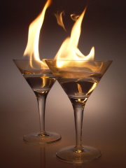 Una foto de copas de cóctel ardiendo ilustra este artículo.