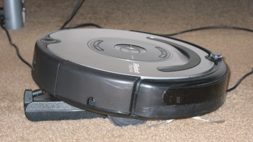 Roomba montada en el cargador del portátil